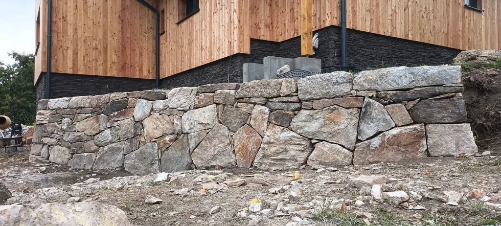 Opěrná zídka zpevněná betonem, beton je schovaný, ve spárách není vidět