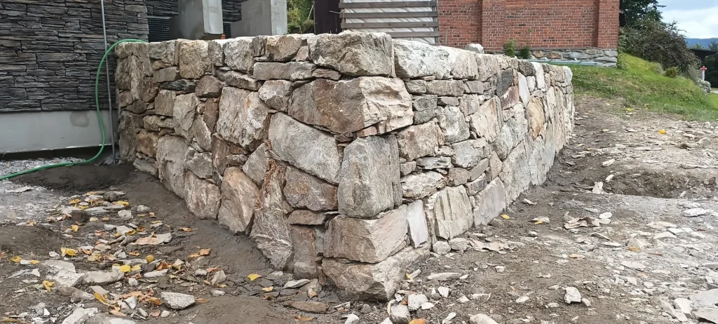 Opěrná zídka zpevněná betonem, beton je schovaný, ve spárách není vidět
